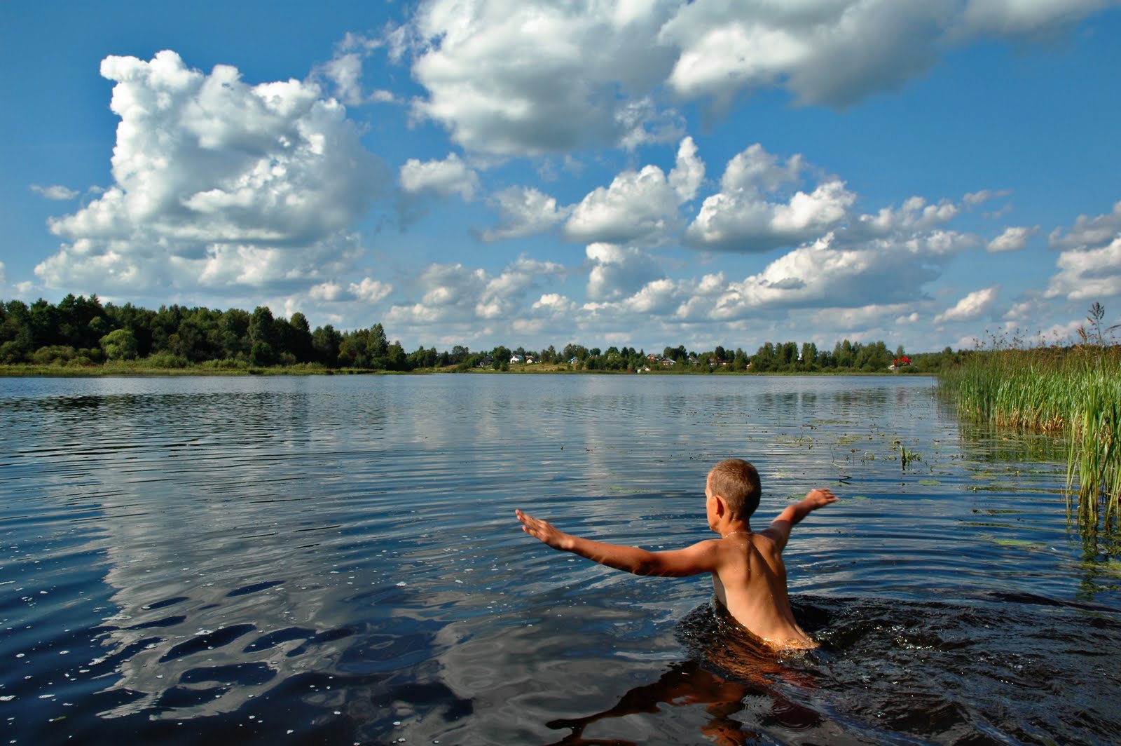 Нудистка входит в воду и плескается в ней