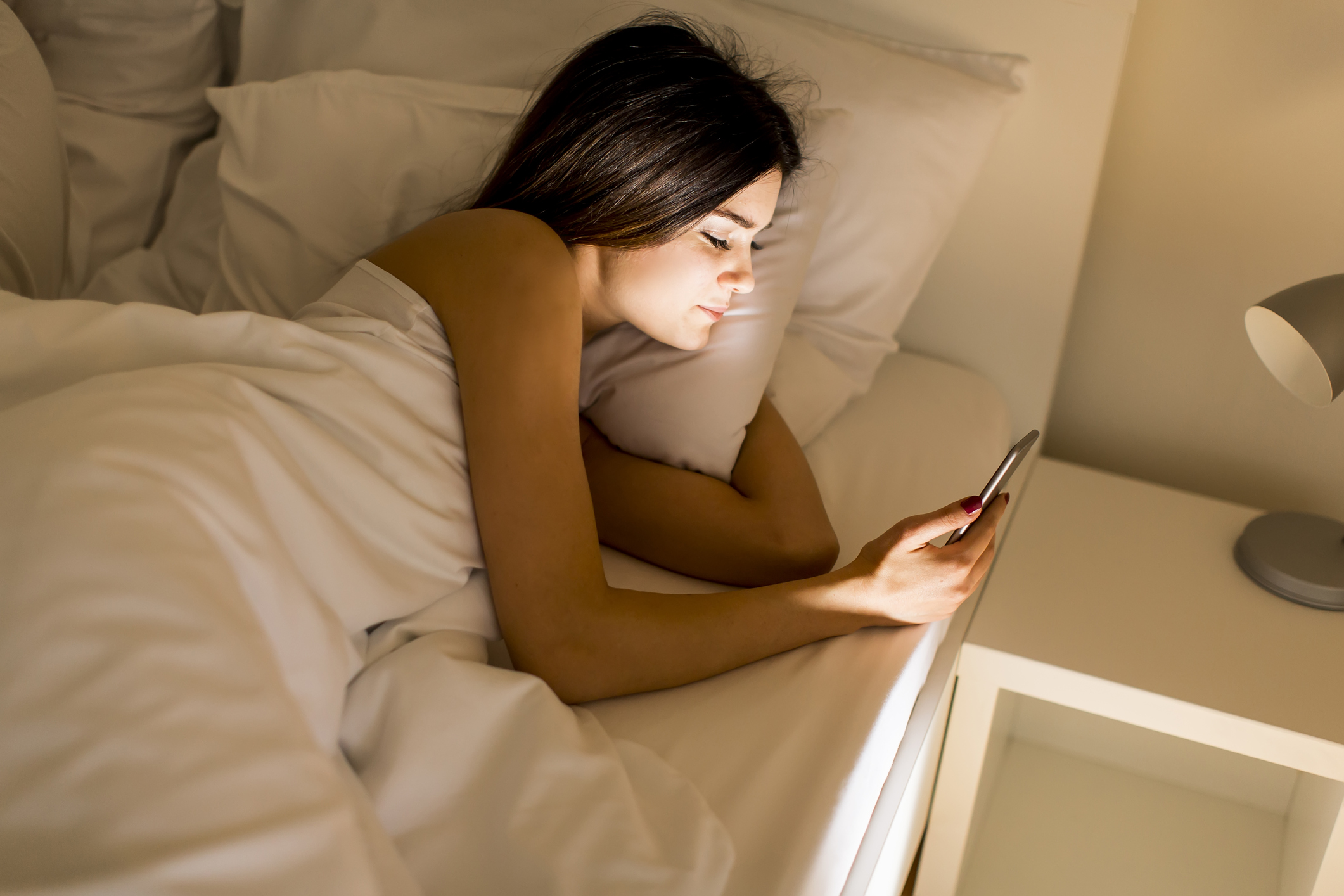 Спишь смс видео. Человек лежит на кровати с телефоном. Человек с телефоном в кровати. Девушка лежит с телефоном.
